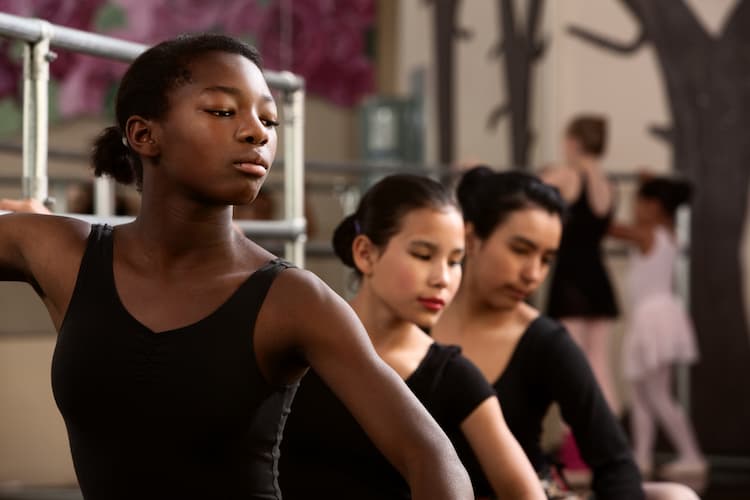 Three young ballet dancers at barre