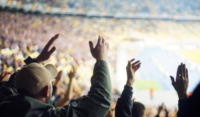 A close up fans cheering at a sporting event