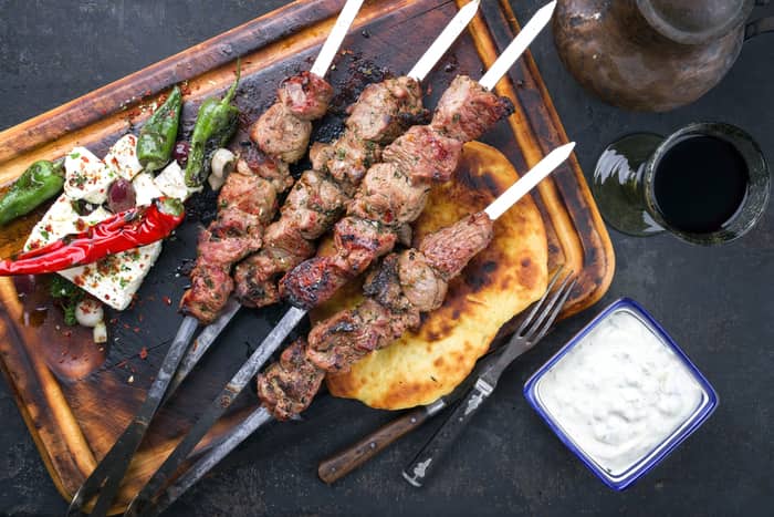 skewers with roasted meat on a wood platter