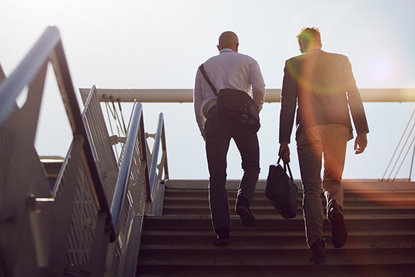 commuters climb stairs on their way to an employee shuttle bus