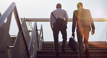 Commuters climb the stairs on the way to an employee bus rental